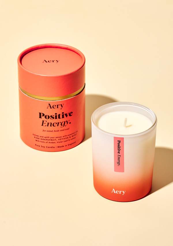 Doftljuset Positive Energy från Aery Living. Ljuset luktar Rosa grapefruit, vetiver och mint. Produkten står framför en beige bakgrund.